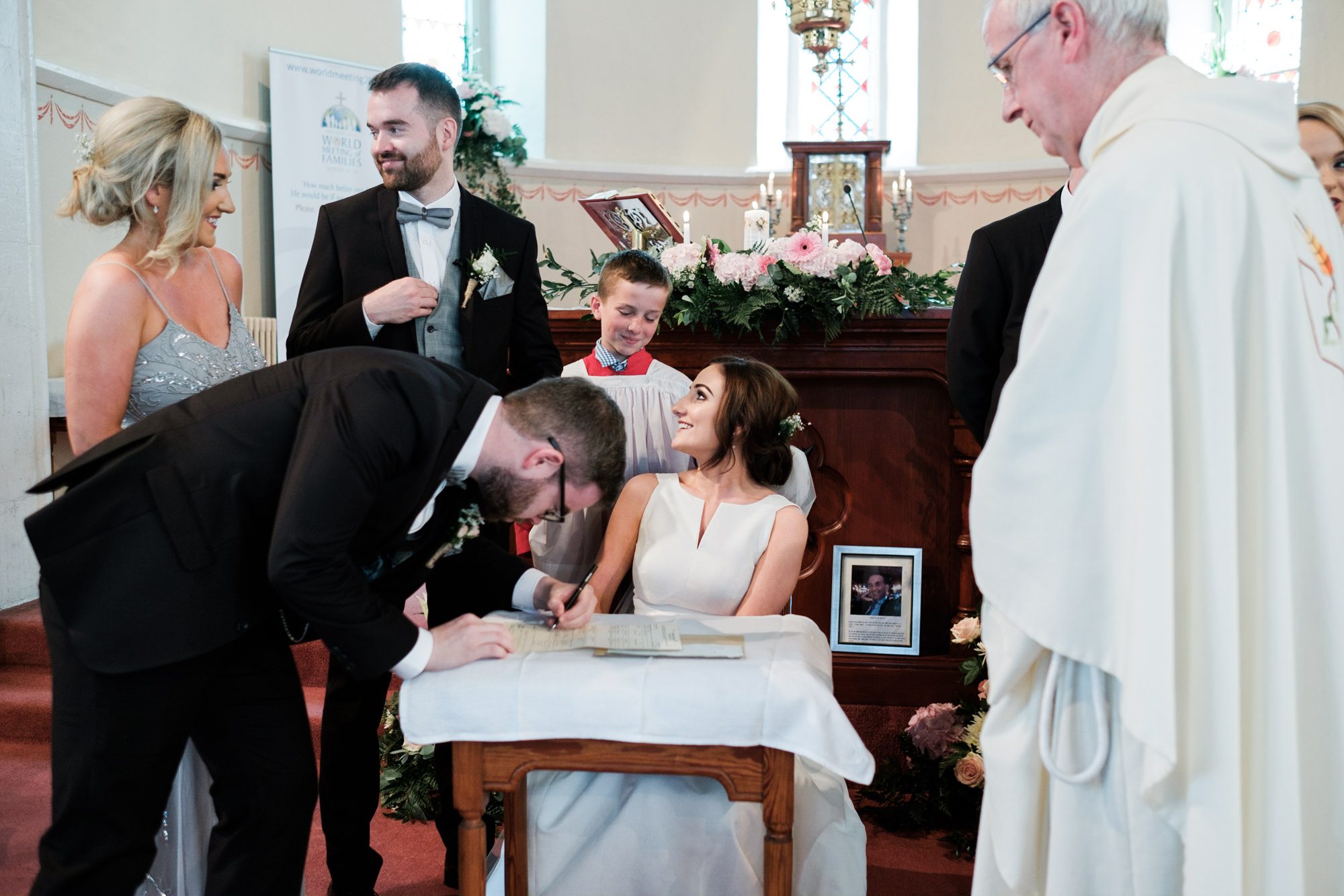 signing the register with altar boy smiling at bride