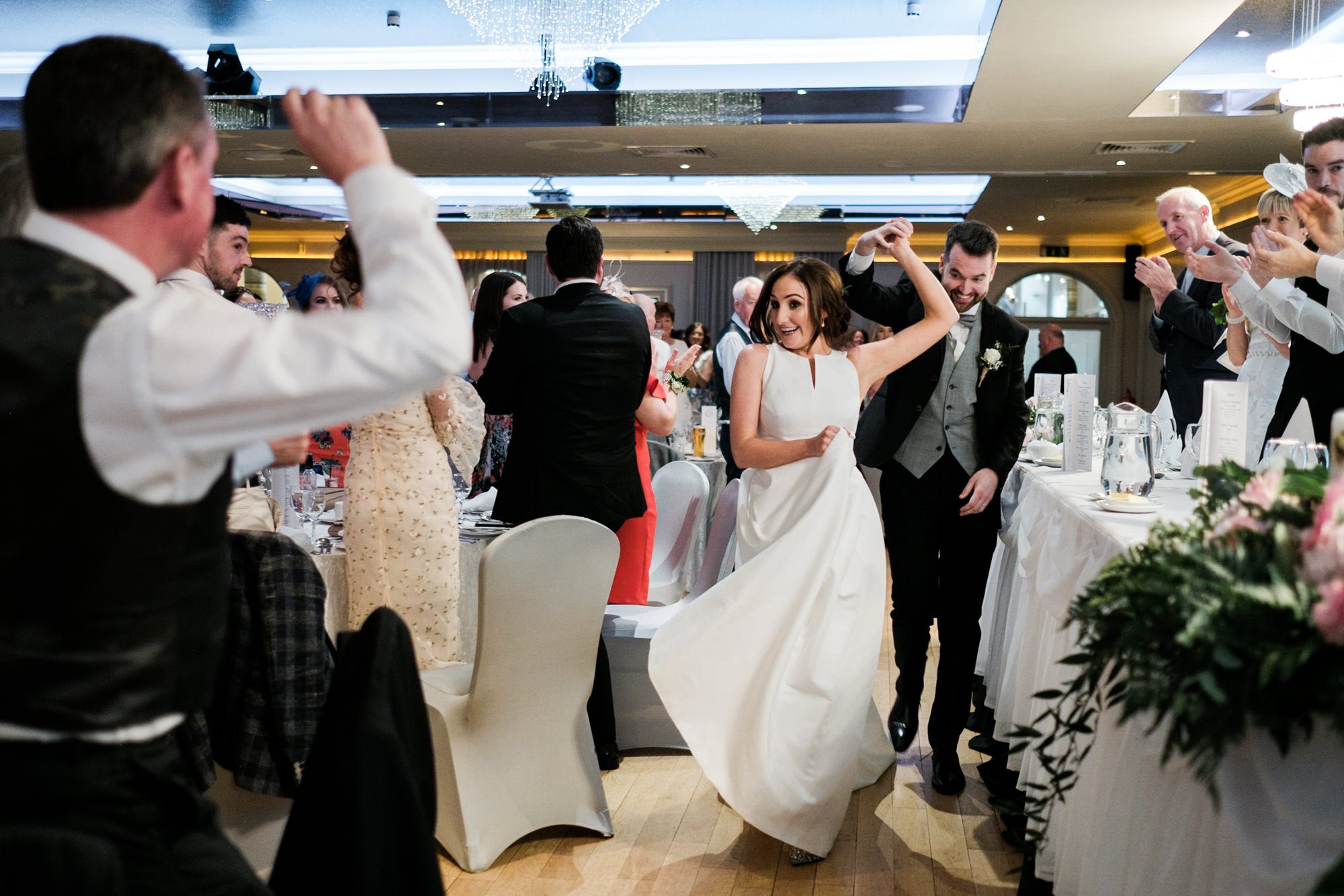 bride and groom dancing into dinner room