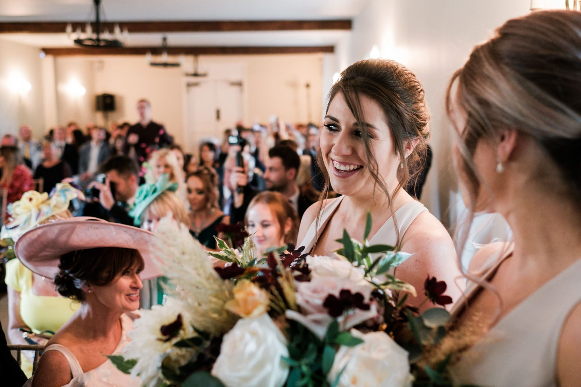 bridesmaid smiling after bride and grooms first married kiss