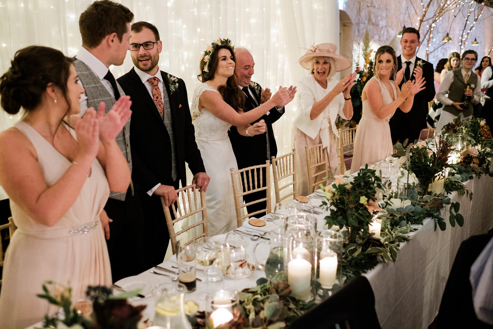 bridal party clapping guests at dinner