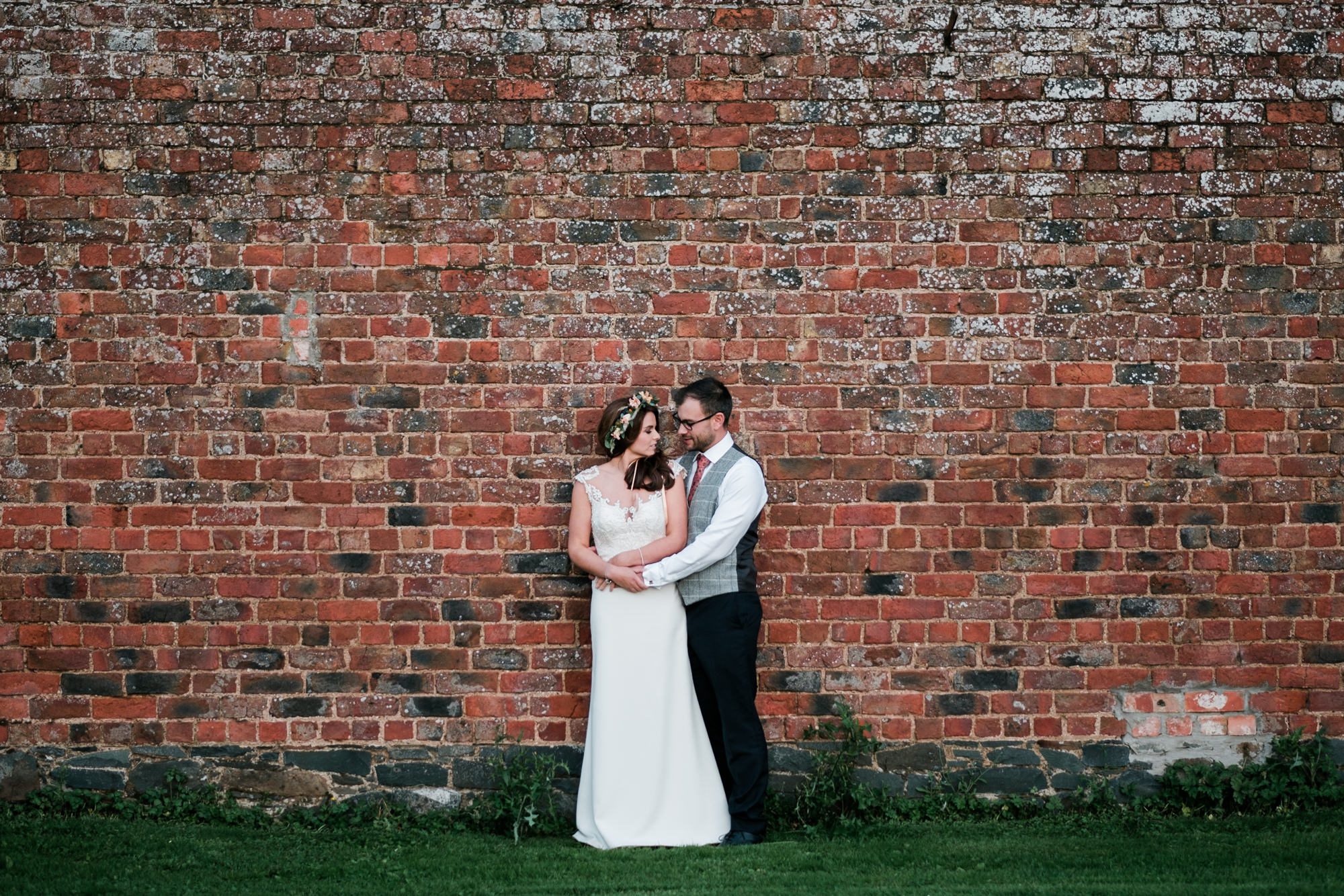 portrait of bride and groom with brick background
