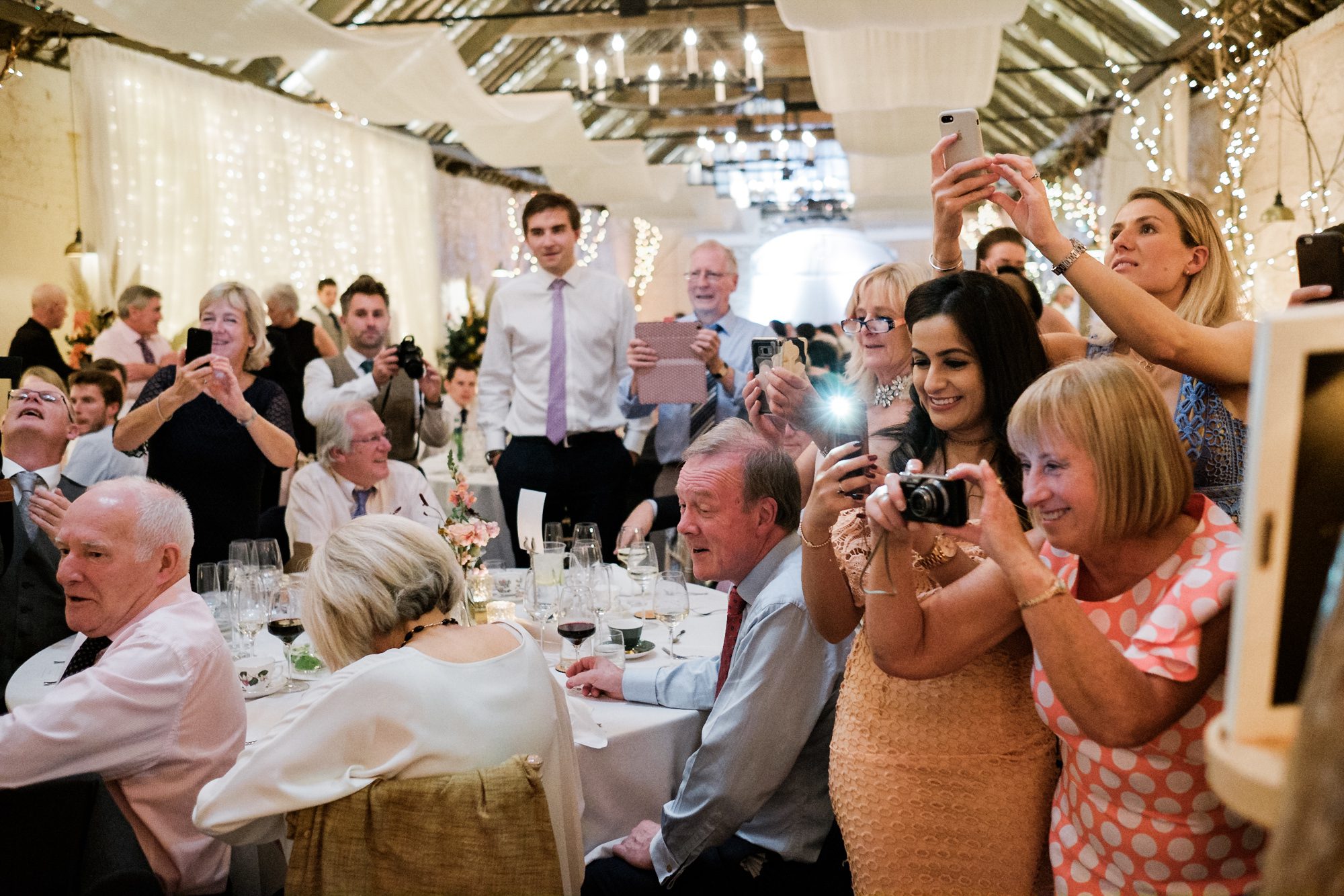guests take photos of cake cutting