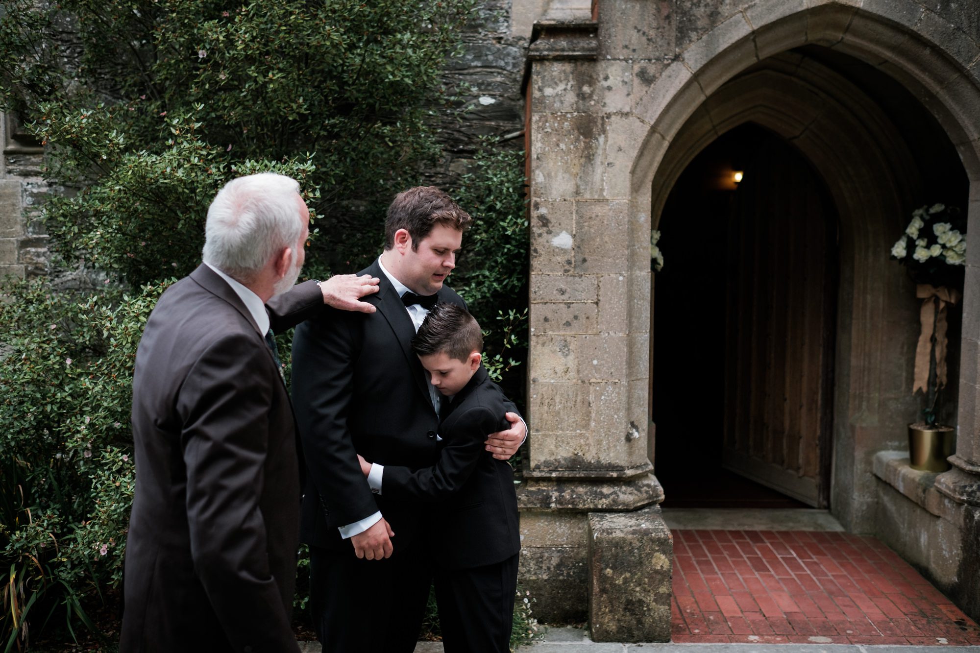 groom and page boy having a hug outside chapel
