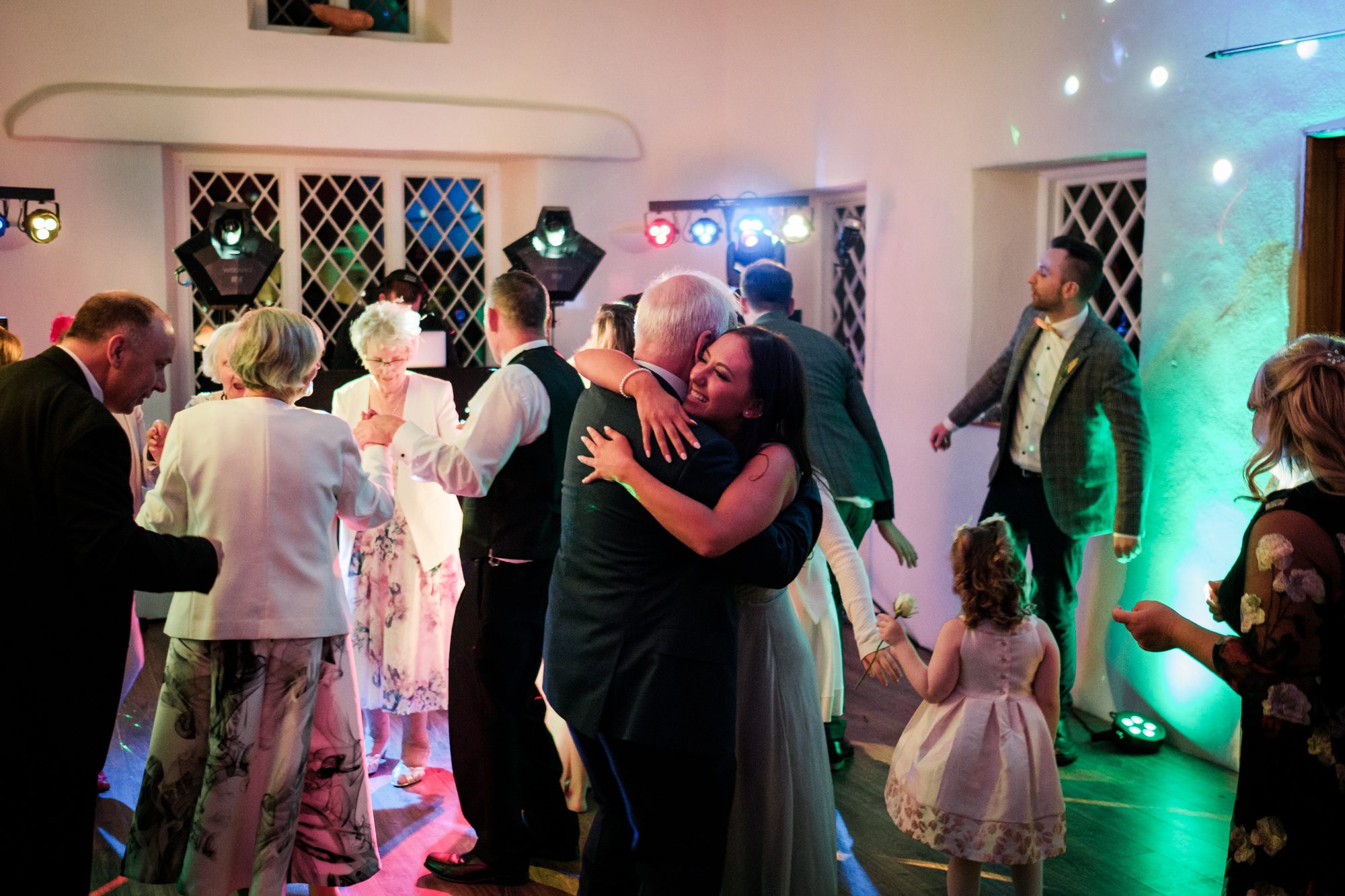 bridesmaid and elderly gentleman hugging on dance floor