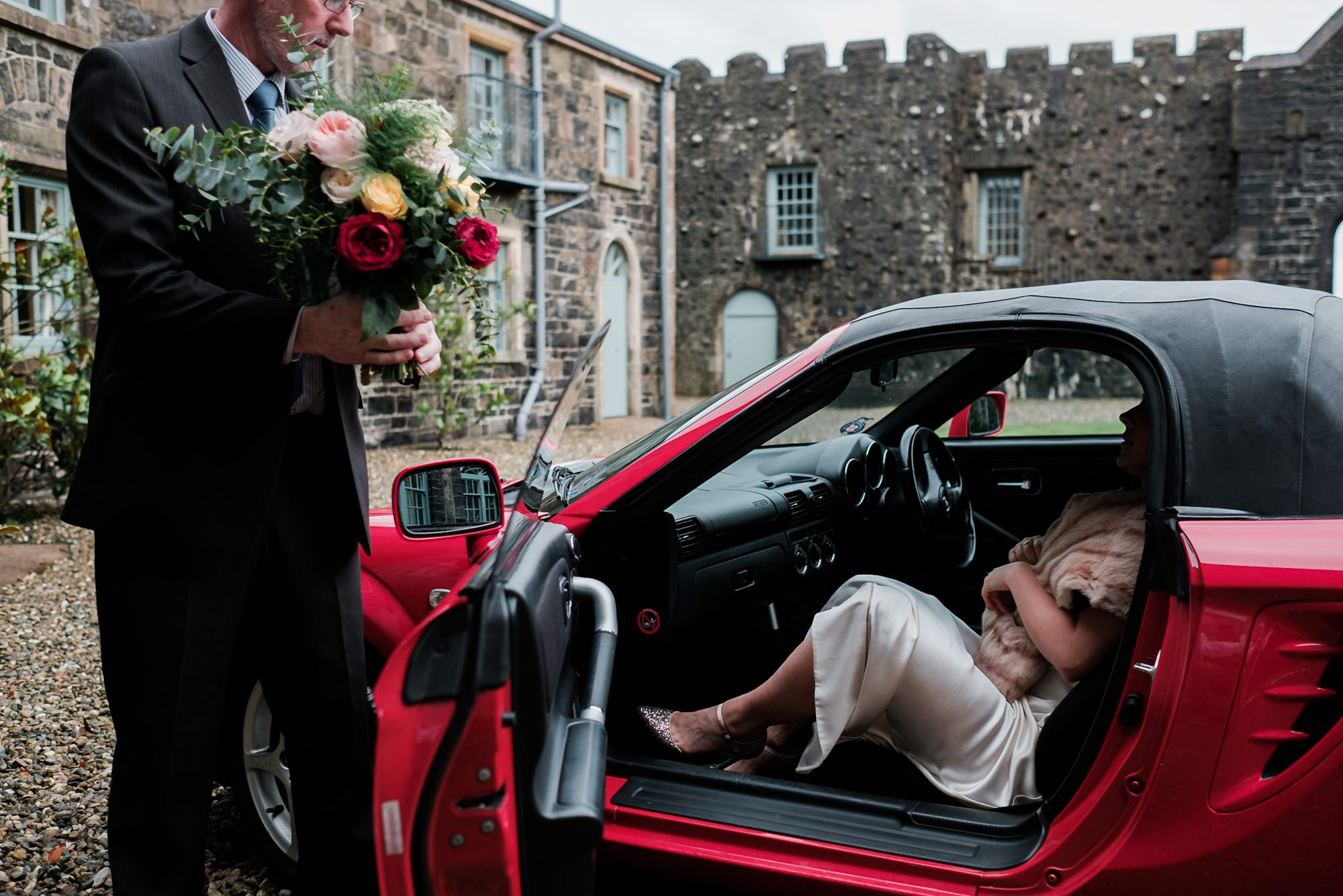 bride arriving in her dad's sports car